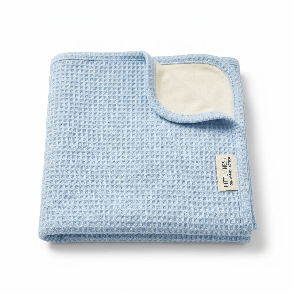 The First-Winter Swaddle in ice blue, folded flat showing honeycomb knit